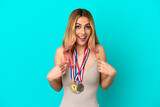 Fototapeta  - Young woman with medals over isolated background with surprise facial expression