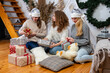 © ako-photography - young girls having fun wrapping gifts at home, great teamwork of friends packing presents for christmas