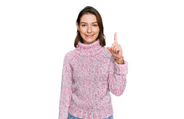 Young caucasian girl wearing wool winter sweater showing and pointing up with finger number one while smiling confident and happy.