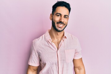 Young hispanic man wearing casual clothes looking positive and happy standing and smiling with a confident smile showing teeth