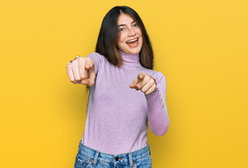 Sticker - Young beautiful teen girl wearing turtleneck sweater pointing to you and the camera with fingers, smiling positive and cheerful