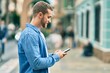 © Krakenimages.com - Young caucasian man smiling happy using smartphone at the city.