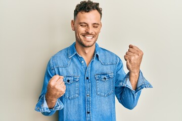 Sticker - Young hispanic man wearing casual clothes celebrating surprised and amazed for success with arms raised and eyes closed