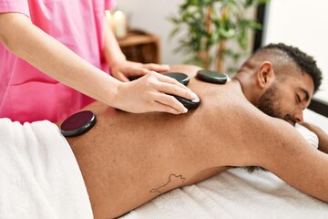 Sticker - Man reciving back massage with black stones at beauty center.