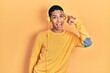 © Krakenimages.com - Young african american guy listening to music using headphones smiling pointing to head with one finger, great idea or thought, good memory