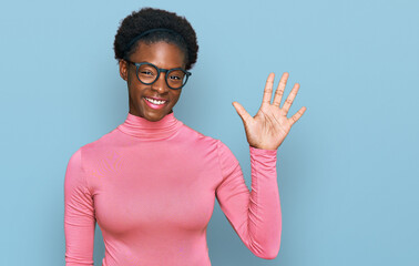 Canvas Print - Young african american girl wearing casual clothes and glasses showing and pointing up with fingers number five while smiling confident and happy.