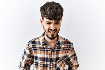 Poster - Hispanic man with beard standing over isolated background with hand on stomach because indigestion, painful illness feeling unwell. ache concept.