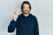 Middle age caucasian man wearing casual sweatshirt showing and pointing up with fingers number three while smiling confident and happy.