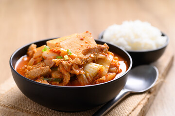 Kimchi soup with tofu and pork in a bowl eating with cooked rice, Korean food