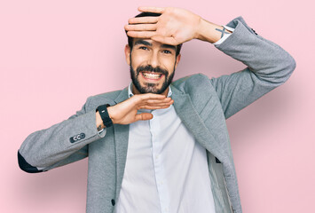 Wall Mural - Young hispanic man wearing business clothes smiling cheerful playing peek a boo with hands showing face. surprised and exited