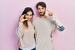 © Krakenimages.com - Young hispanic couple wearing casual clothes smiling and confident gesturing with hand doing small size sign with fingers looking and the camera. measure concept.