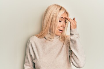 Canvas Print - Young blonde woman wearing casual winter turtleneck sweater surprised with hand on head for mistake, remember error. forgot, bad memory concept.