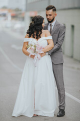 Canvas Print - Beautiful newly-married couple posing in a park for the wedding photoshoot