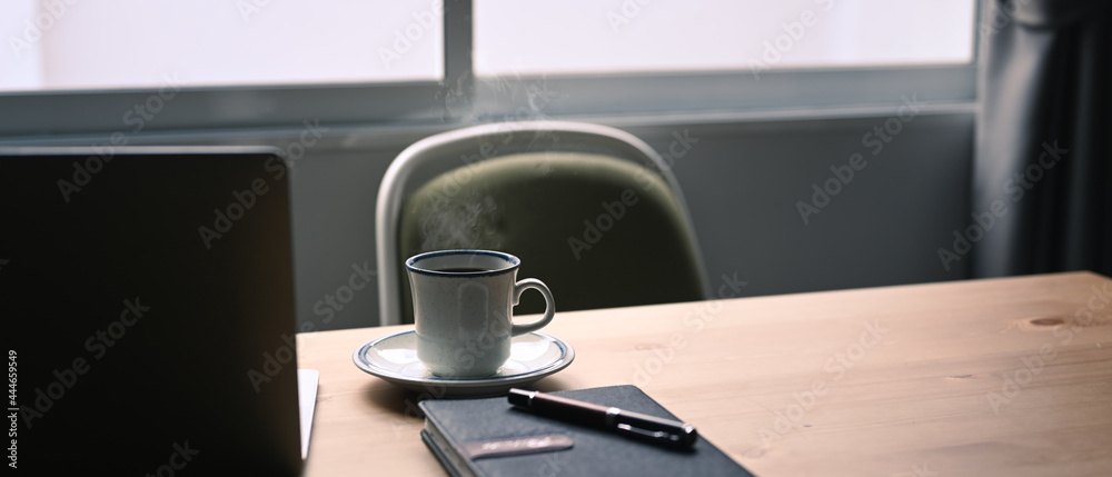 White cup of hot coffee, notebook and laptop computer on wooden table. - obrazy, fototapety, plakaty 