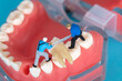 Miniature engineering doll sawing a tooth