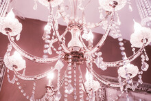 Crystal Chandelier Close-up. Pink Light. Selective Focus.