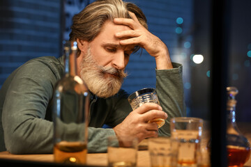 Wall Mural - Drunk senior man with glass of whiskey late in evening at home