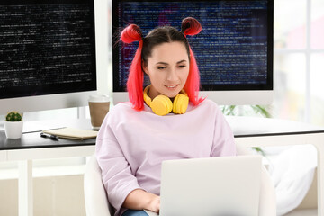 Wall Mural - Female programmer working with laptop in office