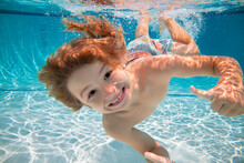 Happy Kid Boy Swim And Dive Underwater, Kid With Fun In Pool Under Water. Active Healthy Lifestyle, Water Sport Activity And Swimming Lessons On Summer Vacation With Child.