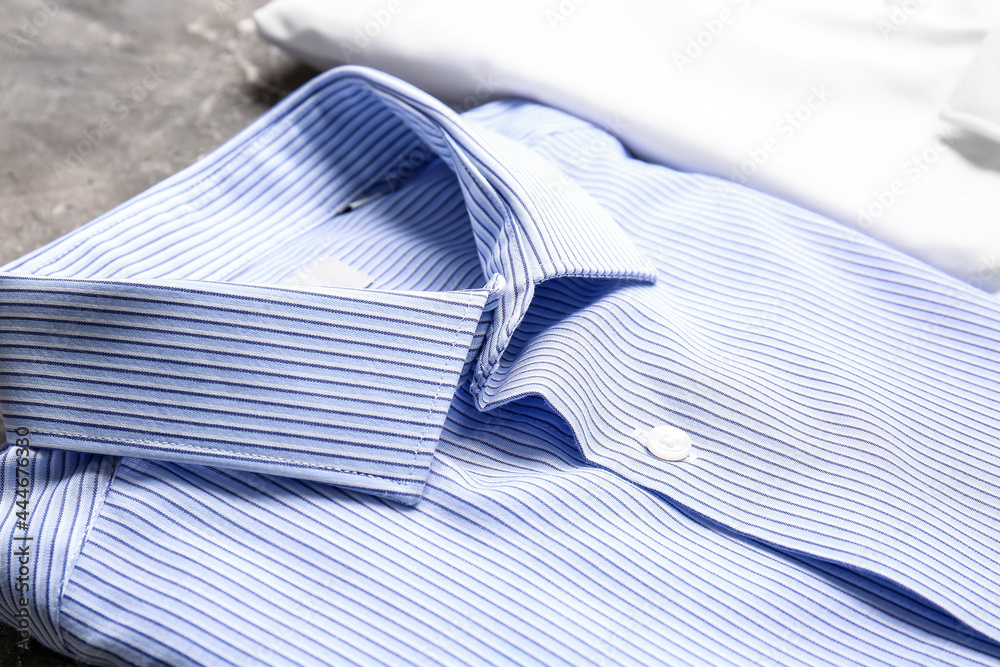 Stylish male shirts on grunge background, closeup