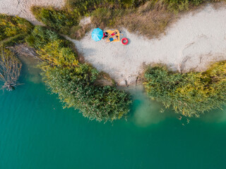 Poster - couple laying on blanket sunbathing at sandy beach blue azure water