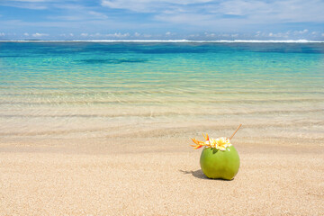 Coconut cocktail decorated with flowers on the beach.