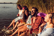 © Zoran Zeremski - Group of friends sitting on the edge of a pier having fun and enjoying a summer day at the lake.