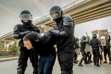 Riot police twisting man at rally