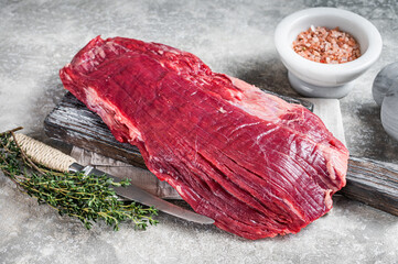 Wall Mural - Fresh Flank or flap raw beef steak on wooden board with herbs. Gray background. Top view