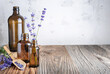 Aromatherapy and essential oil, herbal natural cosmetics, alternative medicine and phytotherapy concept. Bunch of lavender flowers and glass bottles on wooden background