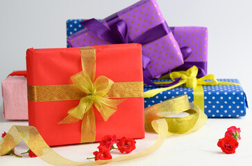 Wall Mural - boxes packed in festive paper and tied with silk ribbon on a white background, birthday gift