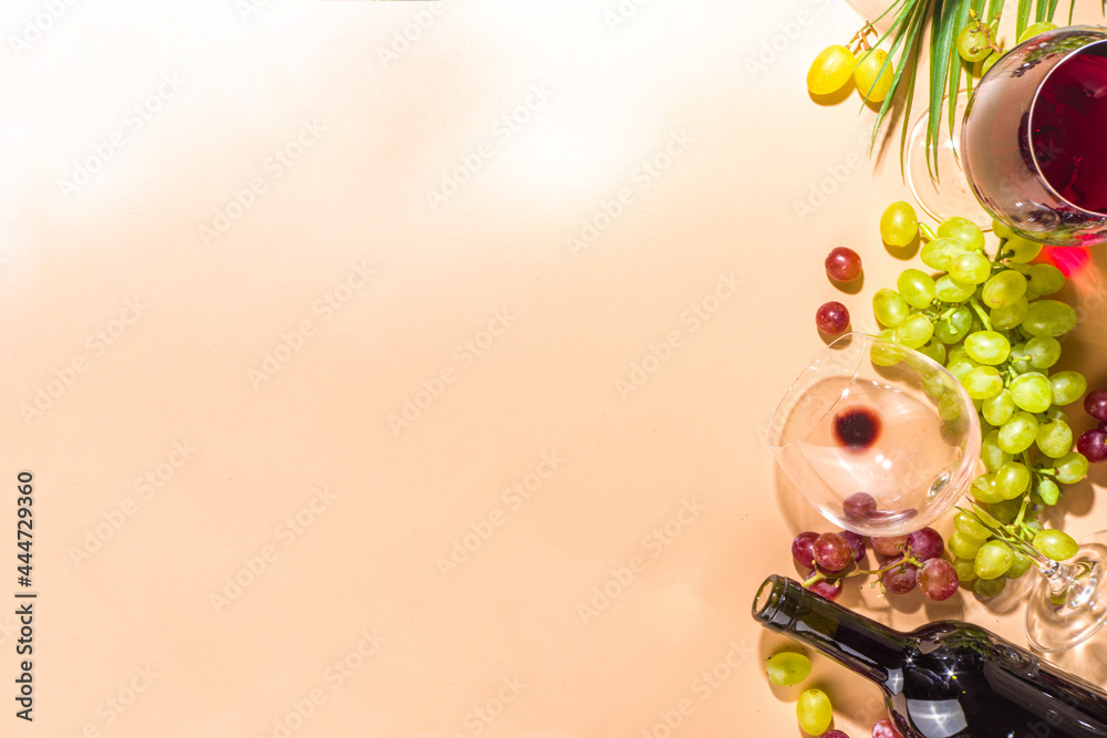 Glasses of red and white wine with sunshine and shadows, with bottle and decanter, bunch of grapes, on creamy color background, flatlay top view Wine tasting, autumn harvest, winery concept - obrazy, fototapety, plakaty 
