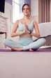 © Monkey Business - Woman Doing Yoga Wearing Fitness Clothing And Activity Monitor Sitting On Floor In Bedroom At Home