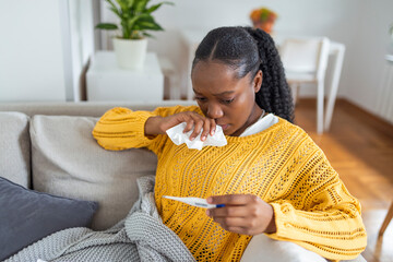 Sickness, seasonal virus problem concept. Woman being sick having flu lying on bed looking at temperature on thermometer. Sick woman lying in bed with high fever. Cold flu coronavirus, covid19