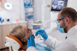 © DC Studio - Stomatolog with senior client examining a patient teeth Elderly woman during medical examination with dentist in dental office with orange equipment.