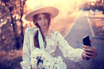 Wall Mural - happy girl with flowers in the city / summer photo young beautiful girl holding a bouquet of flowers