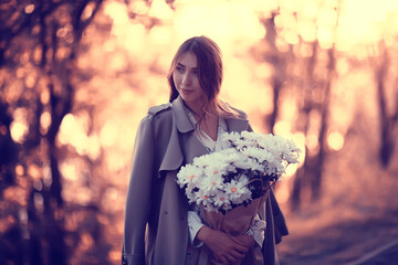 Wall Mural - girl holding a bouquet of flowers a walk in the park / romantic young beautiful cute model, love fee