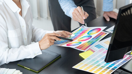 Poster - graphic designer team working on web design using color swatches editing artwork using tablet and a 