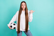 Photo of charming sweet lady wear white sweatshirt holding football ball pointing empty space isolated turquioise color background