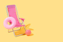 A Pink Beach Chair With A Pink Float And A Ball On Yellow Background. Concept Of Summer And Travel. 3D Illustration. Copy Space