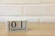 © Елена Николаева - September 1. Wooden calendar on a white brick background with an empty space. The concept of Back to school