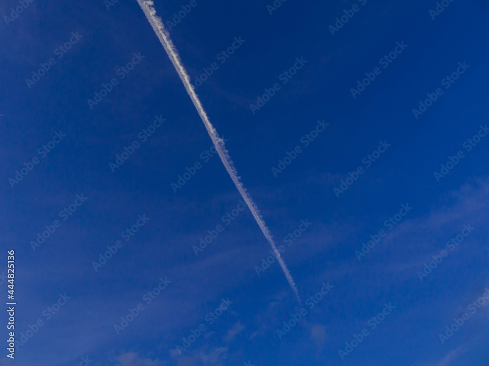 Smuga kondensacyjna na niebie, po przelocie samolotu. - obrazy, fototapety, plakaty 