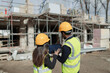 © Paul Bradbury/Caia Image - Engineers with digital tablet at sunny construction site