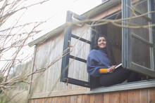 Happy Young Woman In Tiny Cabin Rental Window