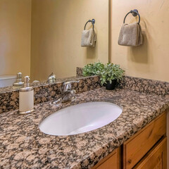 Wall Mural - Square White oval sink on marble countertop with cabinet against huge mirror and light