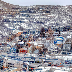 Wall Mural - Square Aerial view of houses and buildings in the residential area of a snowy mountain