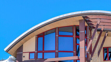 Pano Home exterior with modern design featuring curved roof and large glass windows