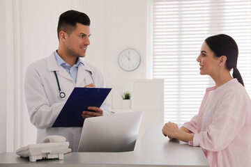 Canvas Print - Doctor working with patient at reception in hospital