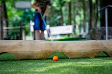 School Kid Boy Playing Mini Golf With Family. Happy Child Having Fun With Outdoor Activity. Summer Sport For Children And Adults, Outdoors. Family Vacations Or Resort.