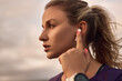 © kegfire - Woman using earbuds during outdoor workout